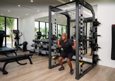 man squatting on gym rax 3d trainer in apartment gym